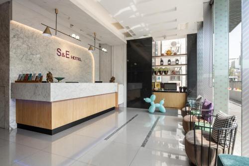 a restaurant lobby with a counter and chairs at S&E Hotel in Tainan