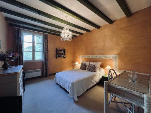 1 dormitorio con cama y lámpara de araña en Mas de la Coquille, en Castries