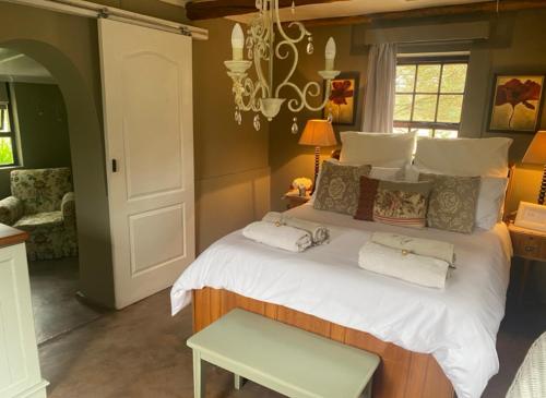 a bedroom with a large bed with towels on it at Staandakkie Guest Cottage in Bredasdorp