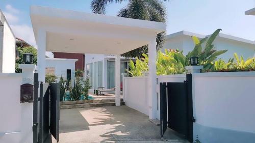 a white house with a gate and a courtyard at Phuket.Rent in Ban Klang