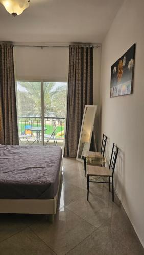 1 dormitorio con 1 cama, mesa y sillas en Luxury villa 4 bedroom with pool access en Ras al-Khaimah