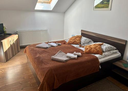 a bedroom with a bed with towels on it at Aranykakas étterem és panzió in Sîndominic