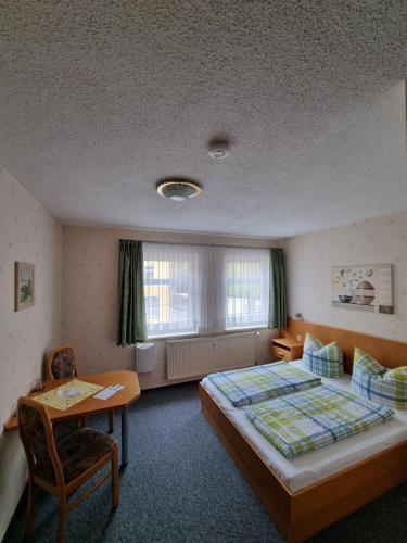 um quarto com uma cama, uma secretária e uma mesa em Pension Schmidt em Bad Kösen