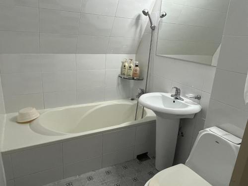 La salle de bains est pourvue d'une baignoire, d'un lavabo et de toilettes. dans l'établissement Gooreumseong motel, à Séoul