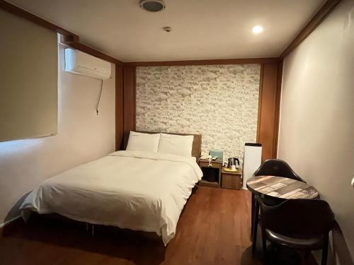 a bedroom with a white bed and a window at Gooreumseong motel in Seoul