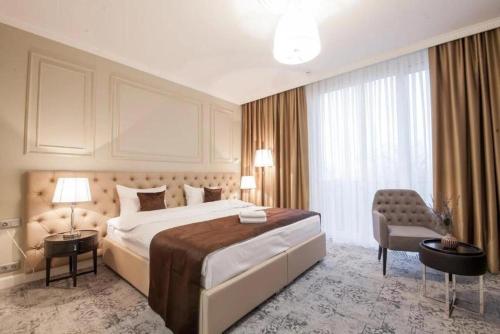 ein Hotelzimmer mit einem großen Bett und einem Stuhl in der Unterkunft Time Hotel&SPA in Chişinău