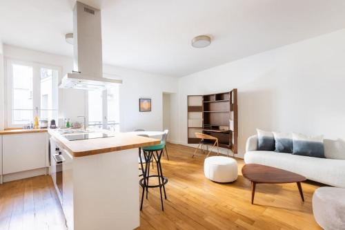 uma cozinha e sala de estar com um sofá e uma mesa em Tour Eiffel - Invalides - Rénové em Paris