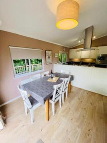 a dining room with a table and chairs in a kitchen at Mariners Lodge in Saint Minver