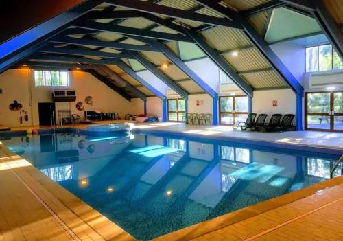 a large swimming pool in a building with an attic at Mariners Lodge in Saint Minver