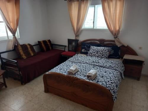 ein Schlafzimmer mit einem Bett und einem Sofa in der Unterkunft Dum u lesa in Biriyya
