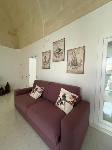a purple couch in a living room with two pillows at Casa di nonna Pina in Manduria