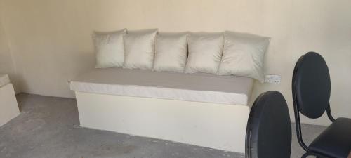 una cama blanca con almohadas blancas en una habitación en SHIMBA SPRINGS MBUYU. ( Malindi), en Malindi