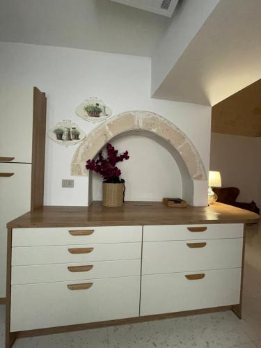 a kitchen with a counter with a arch in the wall at Casa di nonna Pina in Manduria