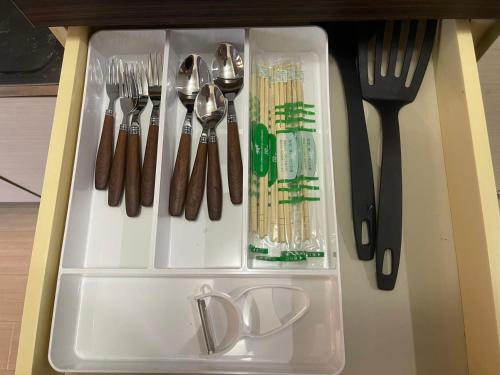 a white tray with forks and spoons and utensils at OKAERI築地町 in Takamatsu