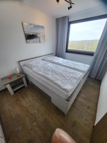 ダンプにあるFerienwohnung Meeresglückのベッドと窓のある寝室