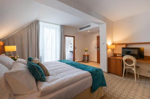 een hotelkamer met een groot bed en een televisie bij Hotel Silenzio in Praag