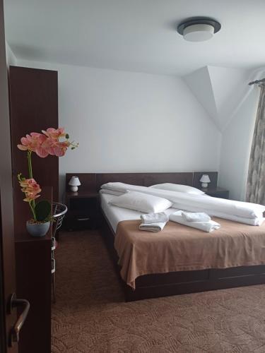 a hotel room with a bed with towels on it at Pensiunea Magura Ocnei in Tîrgu Ocna