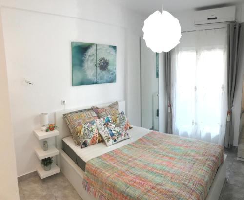a white bedroom with a bed and a large window at *NEW* BEACHFRONT APARTMENT SEA VIEW in Pefkohori