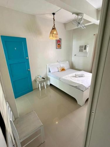 a bedroom with a white bed and a blue door at Caleo Boracay Island Station 3 in Boracay
