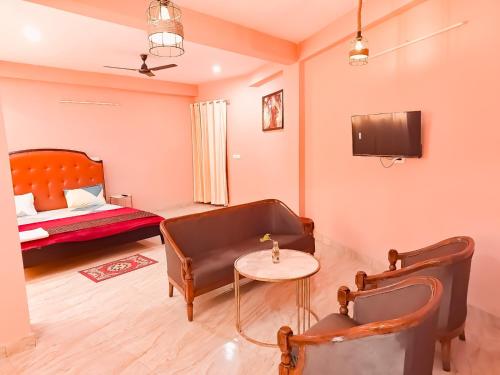 a living room with a couch and a table and a bed at Hotel Rose Inn - Dwarka Sec 8 in New Delhi