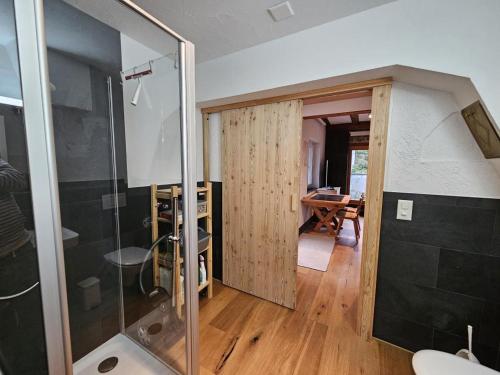 a bathroom with a glass shower and a table at Revier im Bären-Quartier in Haslen