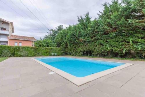 a swimming pool with blue water in a yard at *T2*Vue Garonne*Piscine*Garage* in Toulouse