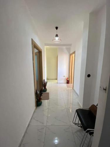 a hallway with a white tile floor and a room at Location juste pour les familles in Mostaganem
