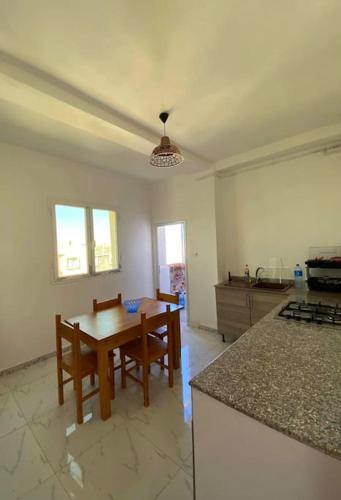 a kitchen with a table and chairs in a room at Location juste pour les familles in Mostaganem