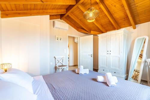 a bedroom with a bed with white towels on it at Villa Konstantina Lulas Penthouse in Petrití