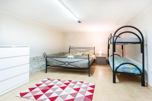 a bedroom with two bunk beds and a rug at Casa Vacanza Olmi in Capitana