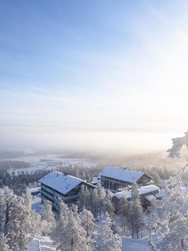 a building in the snow with trees at Ski-Inn Kultakero in Pyhätunturi
