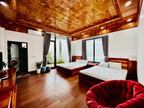 a bedroom with two beds and a red couch at Ruby Tam Đảo in Tam Ðảo