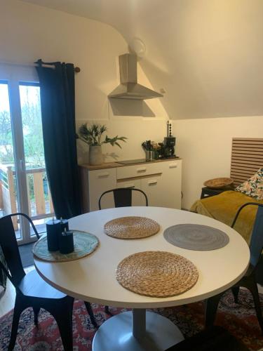 - une table et des chaises dans une pièce avec cuisine dans l'établissement Appartement LES PAQUERETTES, à Janville
