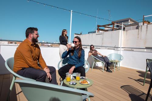 a group of people sitting on a roof at Aila II Hotel Boutique by SingularStays - Digital Access in Burjasot