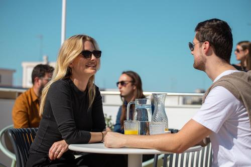 a woman sitting at a table with a man at Aila II Hotel Boutique by SingularStays - Digital Access in Burjasot