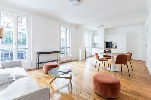 sala de estar con sofá, mesa y sillas en Invalides - Rénové - Luxe, en París