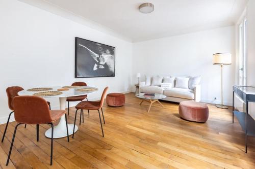 uma sala de estar com uma mesa e cadeiras e um sofá em Invalides - Rénové - Luxe em Paris
