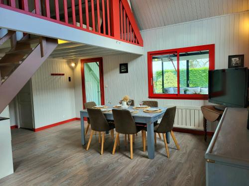 une salle à manger avec une table et des chaises bleues dans l'établissement Maison de bord de mer, à Pirou