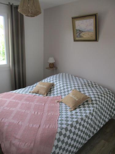 a bed with two pillows on it in a bedroom at GITE LE LILAS in Vierville-sur-Mer