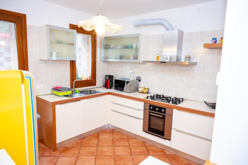 cocina con armarios blancos y fogones en Residence Stradella Verde en Staranzano