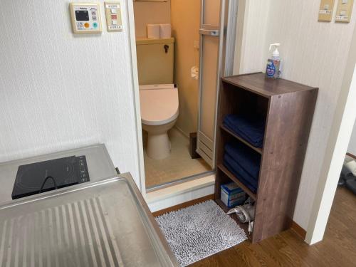 a small bathroom with a toilet and a mirror at OKAERI築地町 in Takamatsu