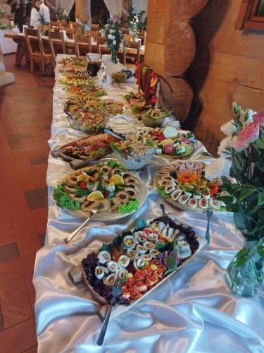 a long table with many plates of food on it at Krynicka Koliba na Jaworzynie Krynickiej in Krynica Zdrój