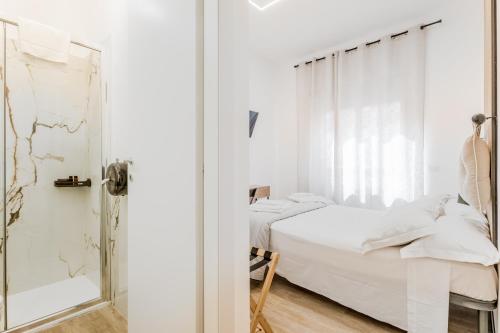 - une chambre blanche avec un lit et une douche dans l'établissement Casa Roma B&B, à Rome