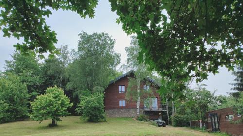 Šumarak Lodge في سراييفو: منزل وسط ساحة فيها اشجار