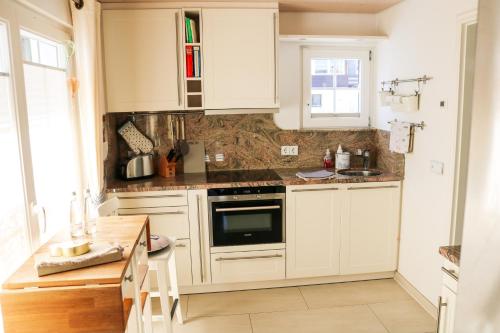 a kitchen with white cabinets and a stove top oven at Wolfsgrund Villa und/oder Apartment - Luxus in Seenähe mit tollem Garten in Schluchsee