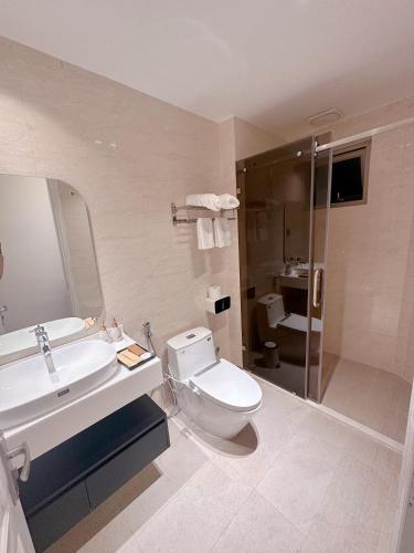 a bathroom with a toilet and a sink and a shower at Malloire House Hue in Hue