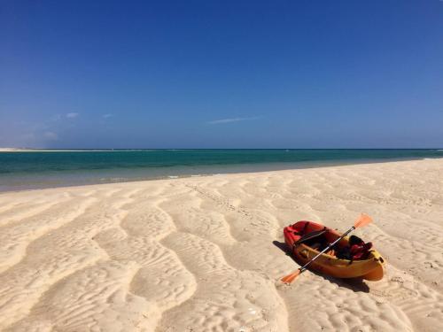a kayak on a beach with a paddle in it at Quinta das Pedras - Tavira in Tavira