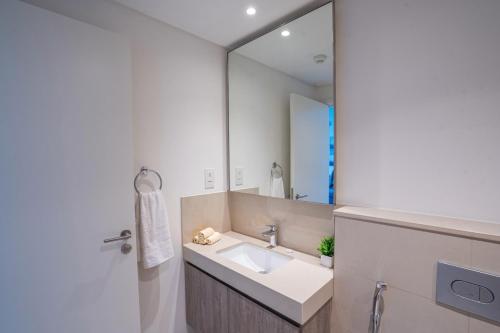 baño con lavabo y espejo grande en Golden Glitter 1 Bedroom in Downtown Dubai, en Dubái