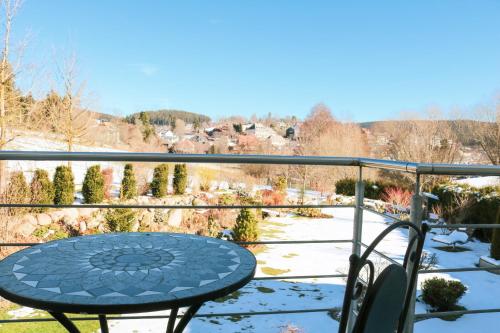 a table on a balcony with snow on the ground at Wolfsgrund Villa und/oder Apartment - Luxus in Seenähe mit tollem Garten in Schluchsee