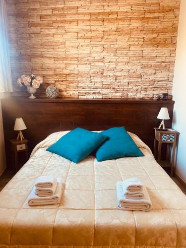 a bed with blue pillows and two towels on it at Isolabella in Mazara del Vallo